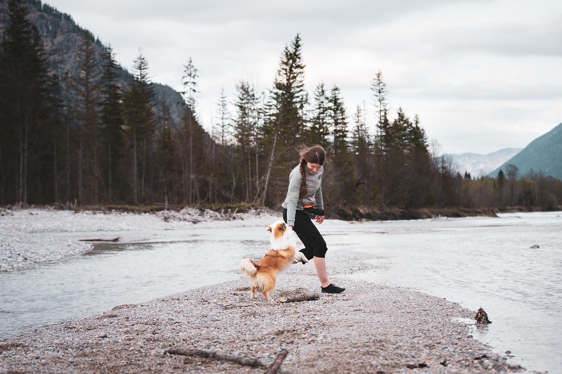 Foto von Birgit und Hund Bolti beim Spielen auf einer Kiesbank der Isar