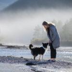 Frau mit Islandhund im Isar-Flussbett bei Bad Tölz bei nebliger Stimmung